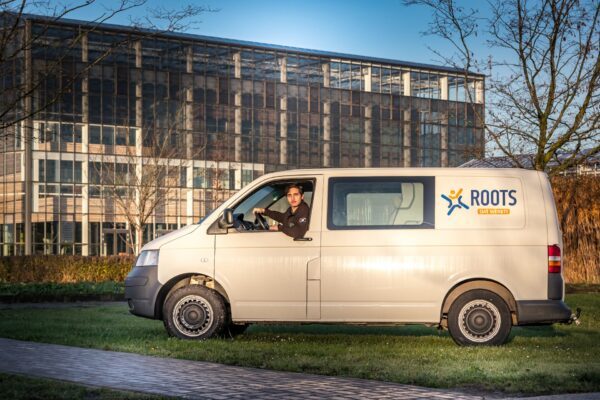 Medewerker Zennie in Roots bus