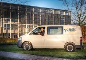Medewerker Zennie in Roots bus