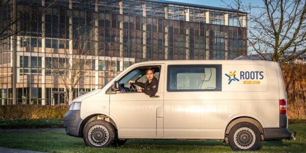 Medewerker Zennie in Roots bus